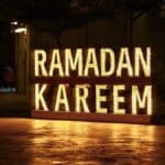 Ramadan kareem is illuminated at night.