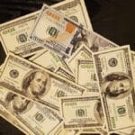 a pile of twenty dollar bills sitting on top of a table
