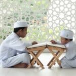 man in white thobe sitting on white floor tiles