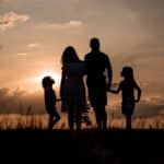a family standing in a field at sunset
