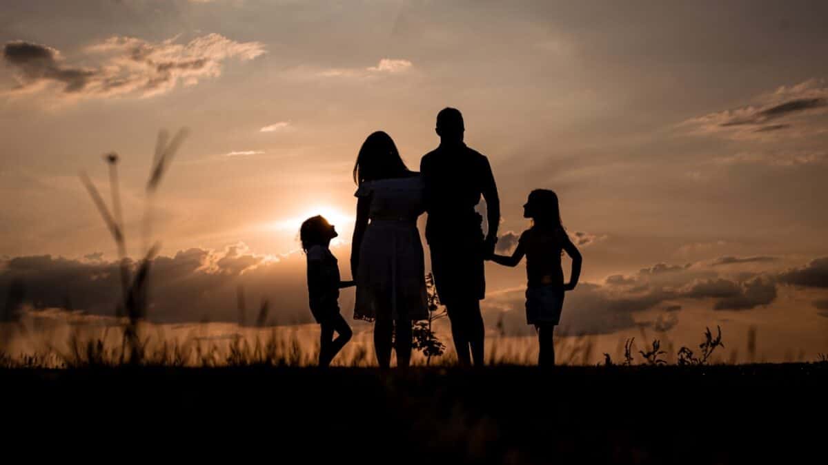 a family standing in a field at sunset