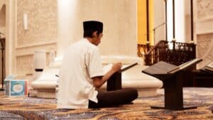 a man sitting on the floor reading a book