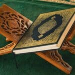 An open book sitting on top of a wooden stand